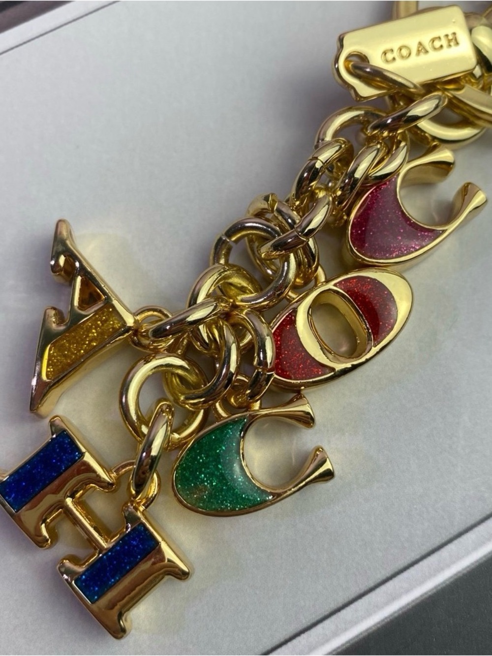 Coach Gold-Tone Charm Bracelet with Blue, Green, Red, Yellow Glitter Letters
